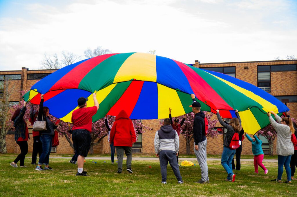 Children playing rainbow parachute game