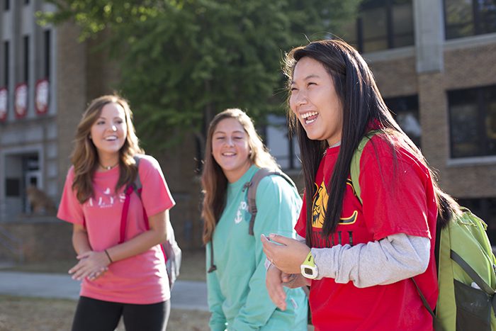 Three Female Students Laughing Outside