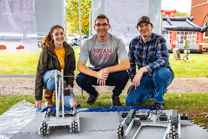 Three Engineering Students Posing with their Robots